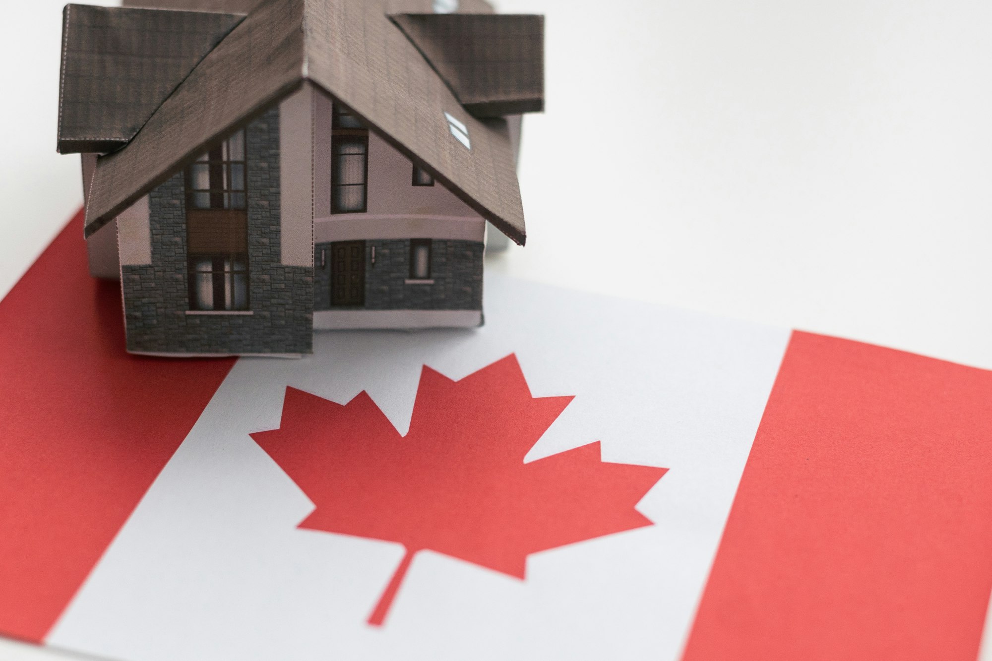 Small house on a flag - Living or migrating to Canada - showing new mortgages for first-time home buyers